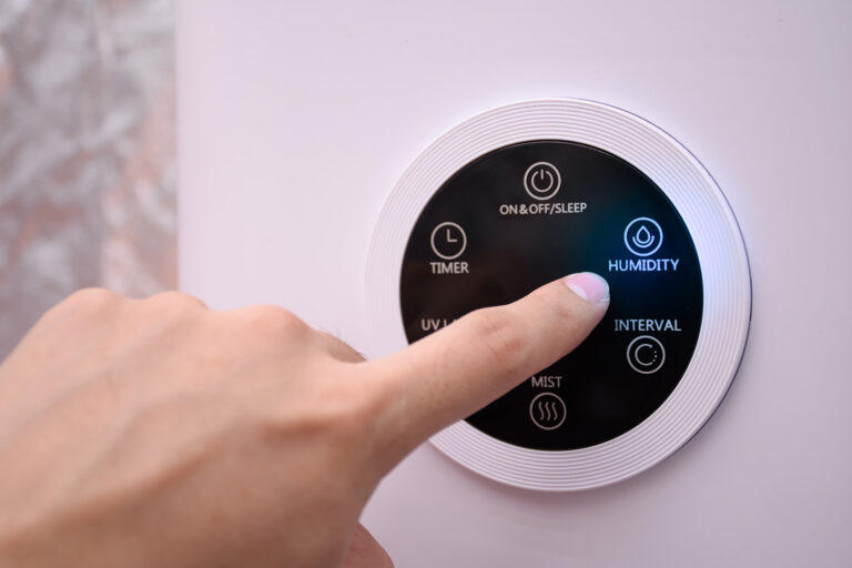 Finger tippt auf Smart-Home-Thermostat