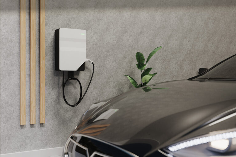 Wallbox an einer Hauswand mit Elektroauto darunter